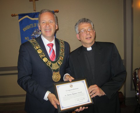 Mayor of St. Catharines, Brian McMullan presents a certificate to Father Michael Basque